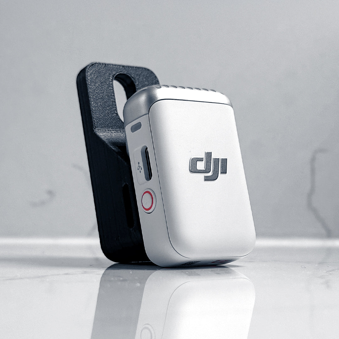 The MicDrop wireless mic mount securely attached to a DJI Mic 2 in White, ready to capture high-quality exhaust audio without wind noise.